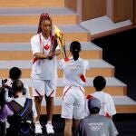 La tenista japonesa Naomi Osaka (c-i) recibe el último relevo de la Antorcha Olímpico