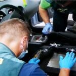 Agentes inspeccionan el doble fondo del vehículo donde ocultaban la droga