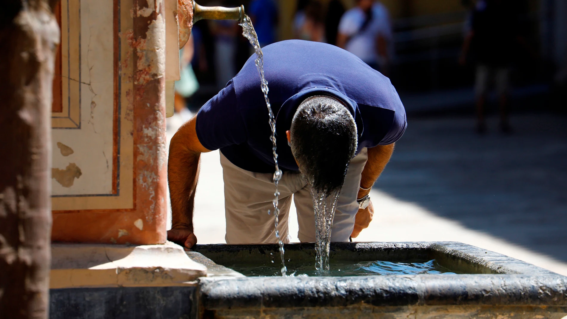 Un visitante se refresca en una fuente del Patio de los Naranjos de la Mezquita Catedral de Córdoba. EFE/Salas