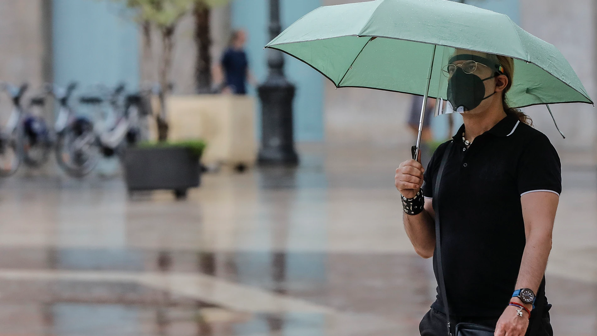 Una persona sostiene un paraguas mientras llueve, a 26 de julio de 2021, en Valencia