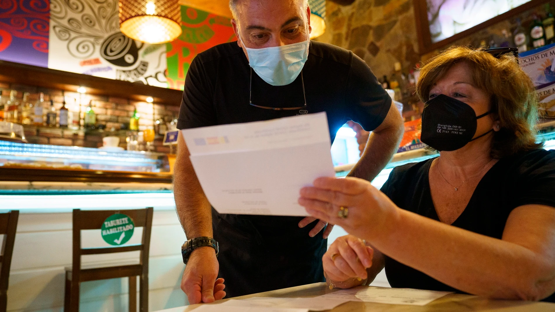 Personal de una cafetería de Santa Cruz de Tenerife comprueba el certificado Covid de una clienta