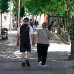 Una pareja de ancianos camina por la calle cogida de la mano, a 27 de julio de 2021, en Madrid, (España)