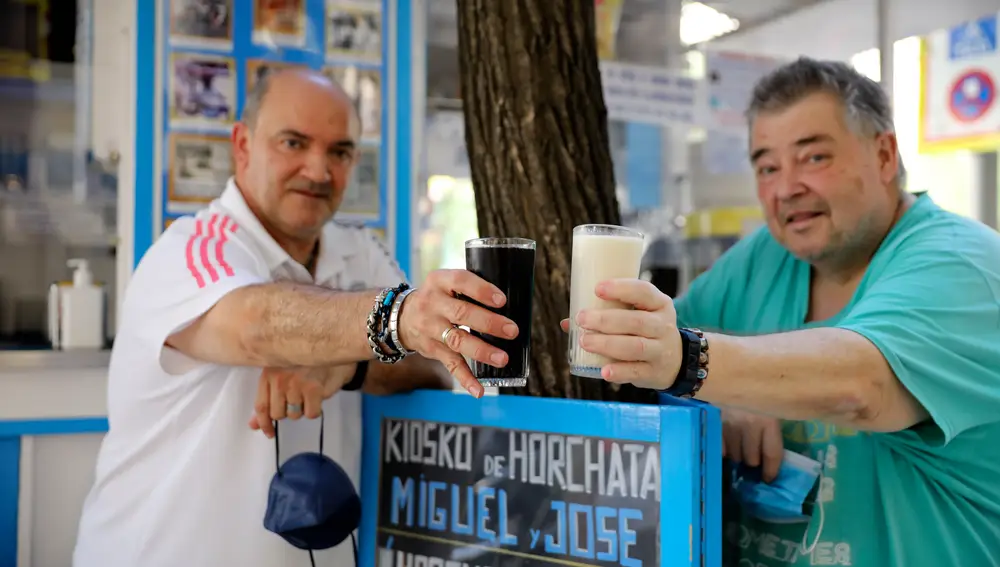 José Manuel y Miguel brindan con una agua de cebada y una horchata en su kiosco.