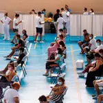 Multitud de jóvenes, con alguna embarazada entre ellos, tras recibir la vacuna contra el coronavirus en el pabellón municipal de Espartinas (Sevilla). EFE/ Raúl Caro.