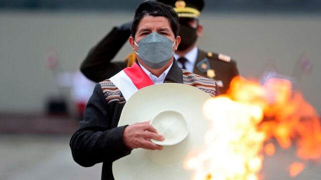 El nuevo presidente de Perú, Pedro Castillo, saluda después de encender un cáliz en honor a las víctimas del coronavirus en una base militar en Lima, Perú