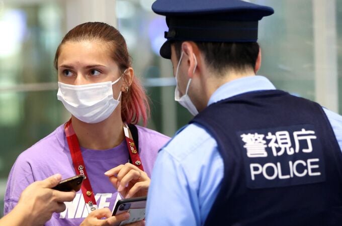 Krystsina Tsimanouskaya, junto a un policía japonés en el aeropuerto internacional de Haneda.