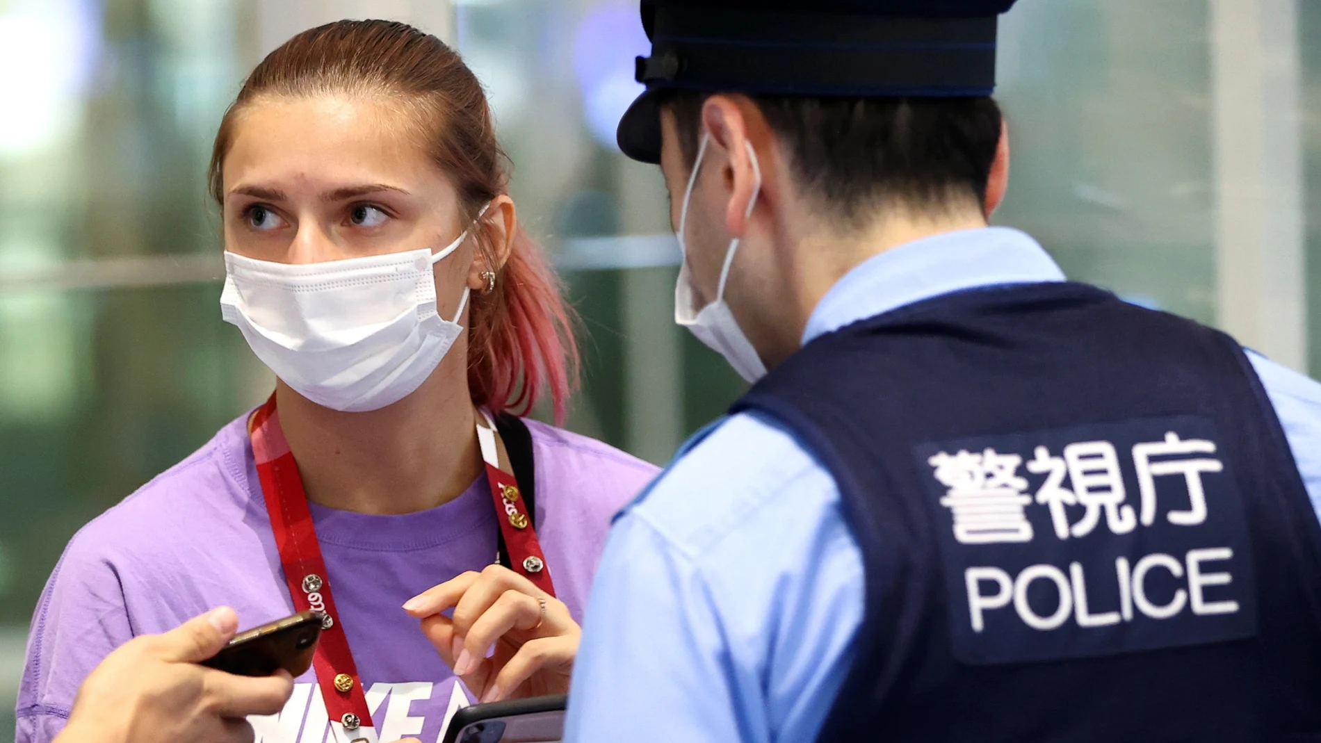 Krystsina Tsimanouskaya, junto a un policía japonés en el aeropuerto internacional de Haneda.