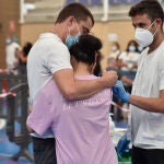 Una joven se abraza a un familiar tras ser vacunada de la primera dosis de la vacuna contra la Covid