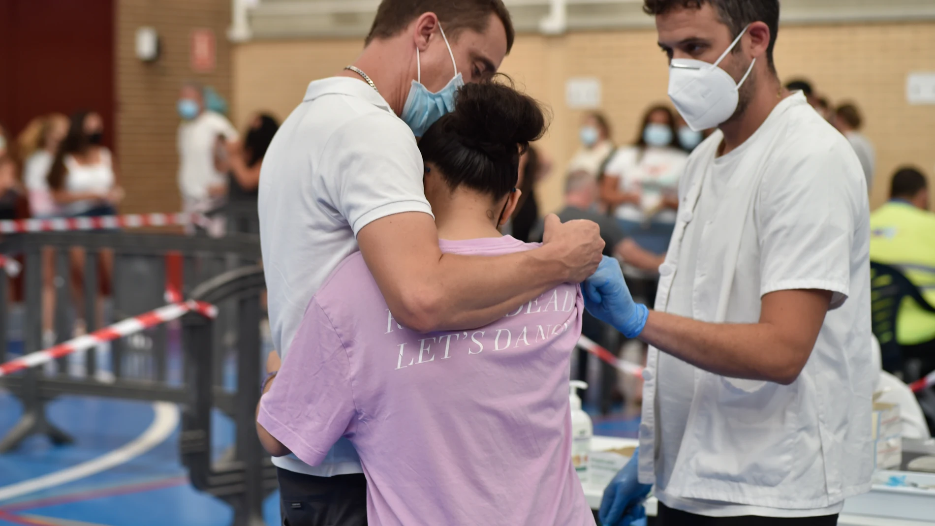 Una joven se abraza a un familiar tras ser vacunada de la primera dosis de la vacuna contra la Covid
