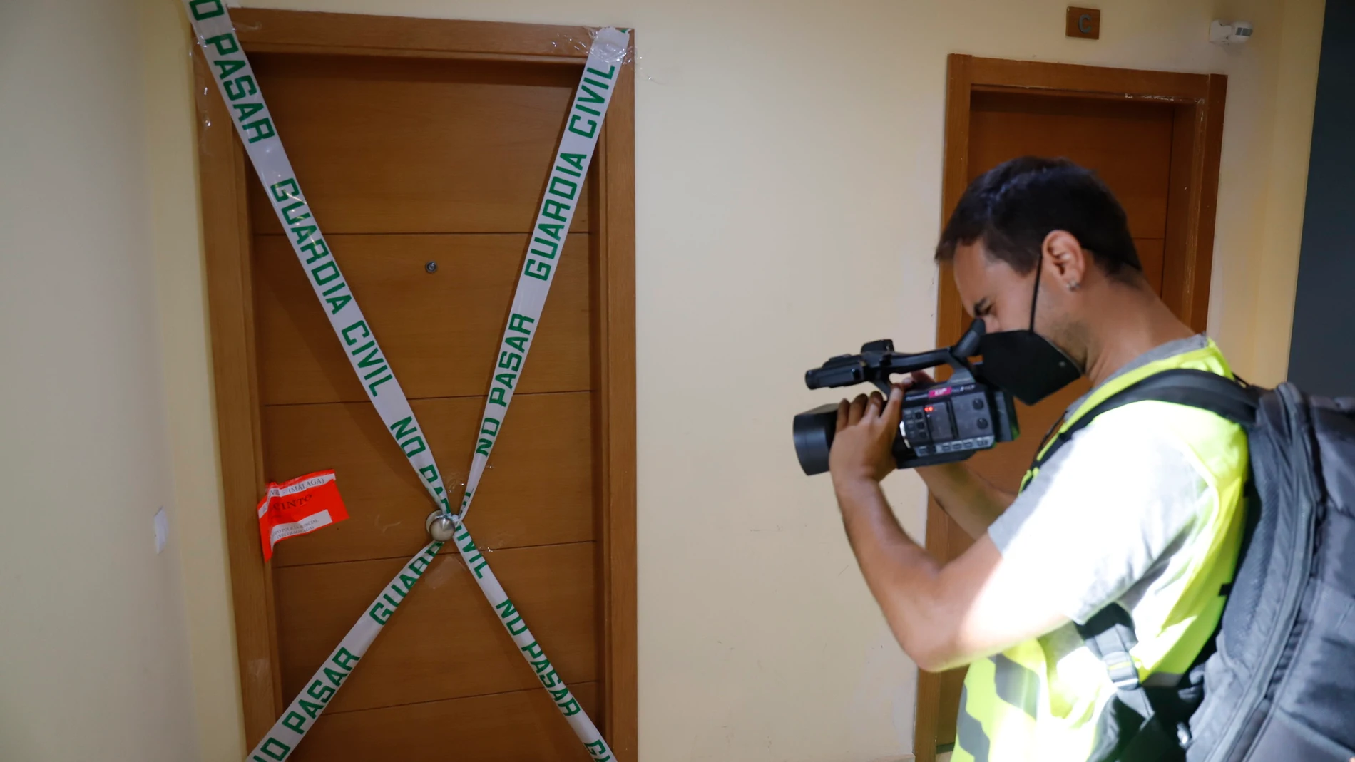 Un cámara toma imágenes de la puerta del domicilio donde presuntamente ocurrió el crimen, en Rincón de la Victoria. Álex Zea / Europa Press