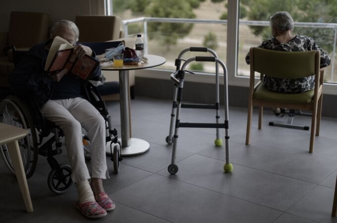 Dos residentes del Centro de Mayores Casablanca Villaverde (Av. de Rafaela Ybarra, 135) leen y descansan en un salón del centro cuatro días después de que se decretase el fin del estado de alarma por el COVID-19.