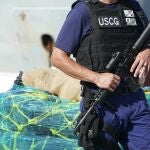 A U.S. Coast Guardsman stands watch near pallets of cocaine, Thursday, Aug. 5, 2021, at Port Everglades in Fort Lauderdale, Fla. The Coast Guard offloaded drugs worth more than $1.4 billion. The agency announced Thursday that the crew of the Cutter James offloaded about 59,700 pounds of cocaine and approximately 1,430 pounds of marijuana. (AP Photo/Wilfredo Lee)