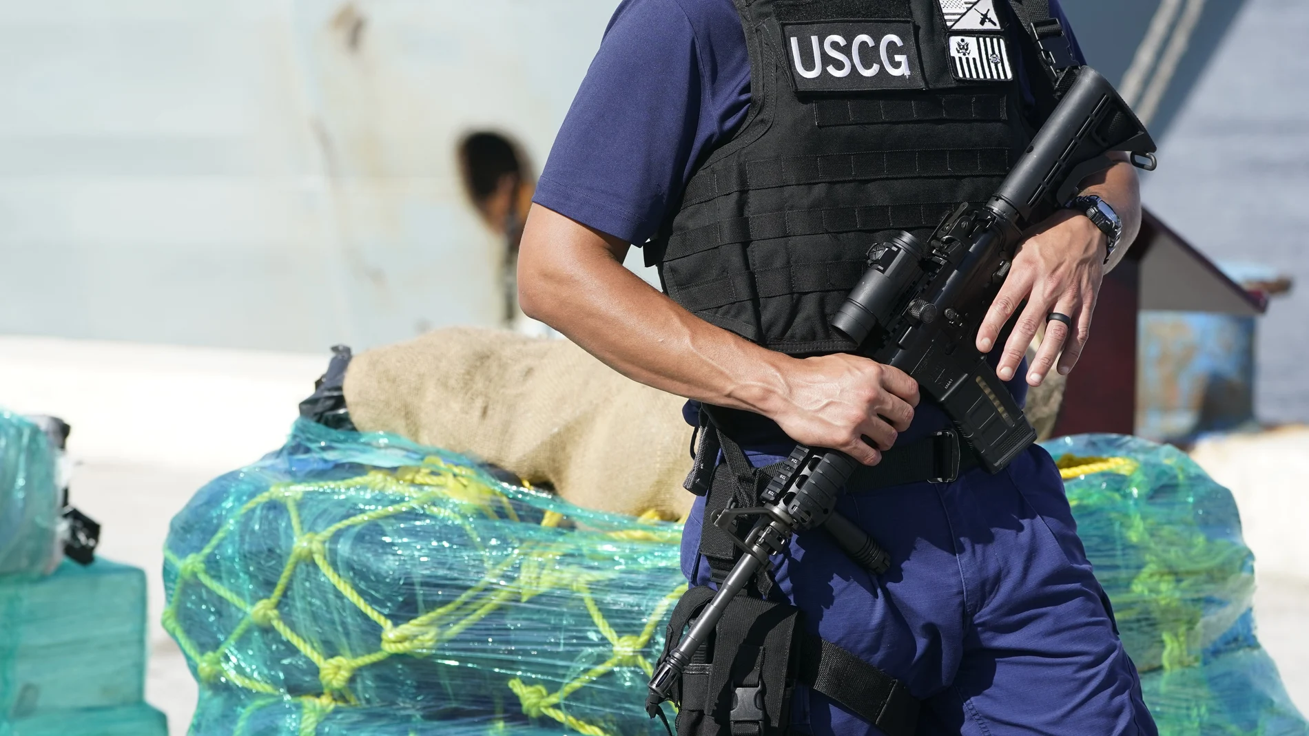 A U.S. Coast Guardsman stands watch near pallets of cocaine, Thursday, Aug. 5, 2021, at Port Everglades in Fort Lauderdale, Fla. The Coast Guard offloaded drugs worth more than $1.4 billion. The agency announced Thursday that the crew of the Cutter James offloaded about 59,700 pounds of cocaine and approximately 1,430 pounds of marijuana. (AP Photo/Wilfredo Lee)