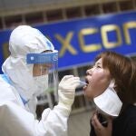 Un médico realiza un teste de covid-19 en Wuhan, China