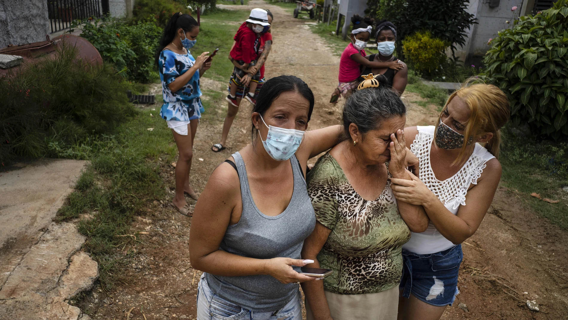 Zuleydis "Zuly" Elledias, right, along with her sister Sudenis, comfort their mother who cries for missing relatives who disappeared when they ventured out in a homemade boat in an attempt to reach Florida, in Orlando Nodarse, about 60 kilometers west of Havana , Cuba, Wednesday, June 30, 2021. Cuba is seeing a surge in unauthorized migration to the United States, fueled by an economic crisis. (AP Photo/Ramon Espinosa)