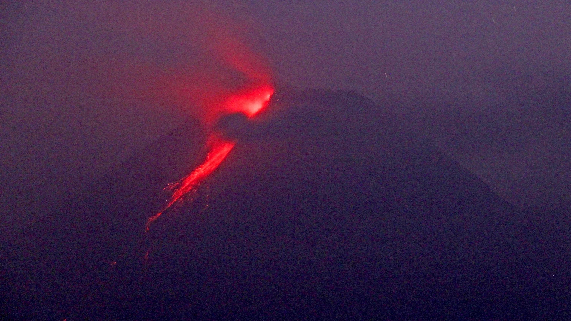 In this photo taken using slow camera shutter speed, hot lava runs down from the crater of Mount Merapi, in Sleman, Yogyakarta, Indonesia, early Monday, Aug. 9, 2021. Indonesia's most volatile volcano on the densely populated island of Java was erupting again Monday with searing gas clouds and lava flowing fast down its slopes. (AP Photo/Slamet Riyadi)
