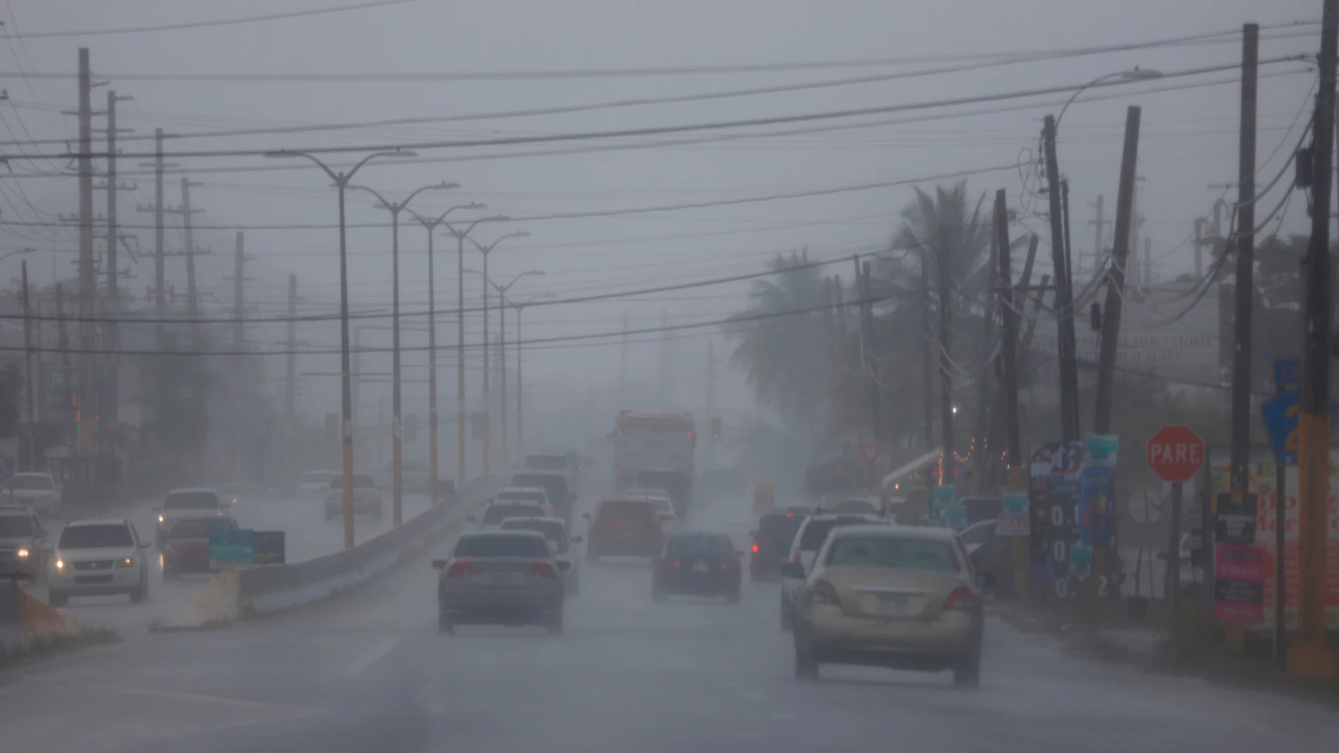 -FOTODELDIA- AME7862. VEGA ALTA (PUERTO RICO), 10/08/2021.- Carros transitan hoy por la Carretera 2 en plenas lluvias y entre la alerta por la posible tormenta tropical Fred, en Vega Alta (Puerto Rico). Puerto Rico se prepara para la llegada este martes de lo que podría llegar a ser la tormenta tropical Fred, que se espera deje en la isla hasta 10 centímetros de lluvia y vientos de hasta 56 kilómetros por hora, especialmente en el suroeste. Se ha ordenado que los funcionarios cesen sus labores a partir del mediodía, con excepción de quienes trabajan en servicios esenciales, según el gobernador Pedro Pierluisi. EFE/ Thais Llorca