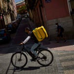 Trabajadores riders con su bicicleta en las calles de Madrid para el reparto de comida