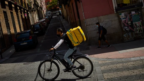 Trabajadores riders con su bicicleta en las calles de Madrid para el reparto de comida