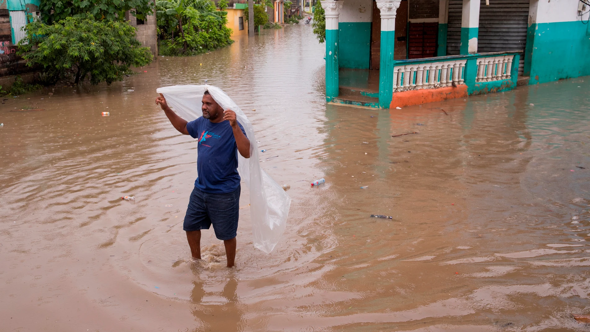 -FOTODELDIA- AME8333. SAN CRISTÓBAL (REPÚBLICA DOMINICANA), 12/08/2021.- Un hombre camina por una de las calles inundadas en el barrio Moscú tras el paso de la tormenta Fred, hoy, en San Cristóbal (República Dominicana). Un total de 580.186 usuarios quedaron sin agua y 439.263 sin electricidad por los efectos de Fred sobre la República Dominicana, donde ayer como tormenta tropical arrojó fuertes lluvias, según el reporte ofrecido este jueves por el Centro de Operaciones de Emergencias (COE). EFE/ Orlando Barría