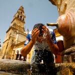 Un turista se refresca en el Patio de los Naranjos de Córdoba, ciudad en la que se superaron los 46 grados durante el sábado