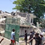 Las personas se agolpan a las puertas del Obispado de Les Cayes derrumbado como consecuencia del fuerte seísmo registrado hoy