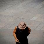 Un hombre se protege la cabeza del sol con un sombrero.