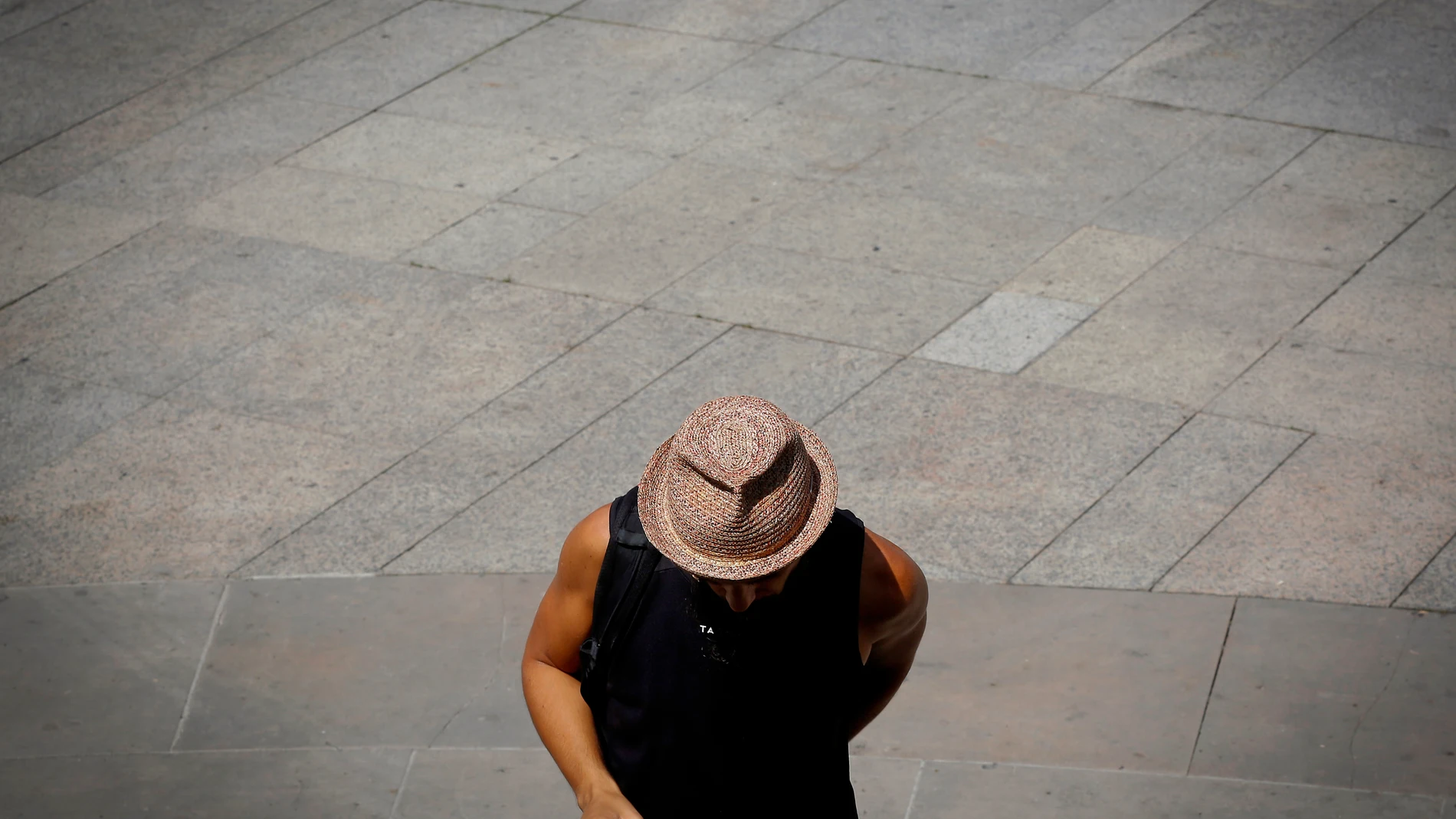 Un hombre se protege la cabeza del sol con un sombrero.