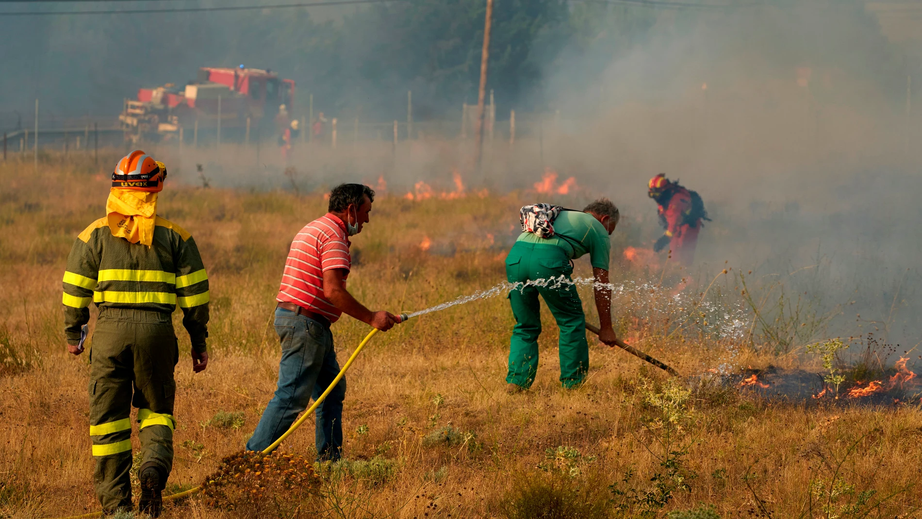Bomberos y vecinos trabajan en las labores de extinción del incendio declarado ayer en los municipios abulenses de Navalacruz y Cepeda de la Mora y La Parra