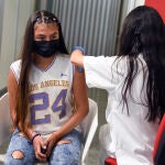Una sanitaria vacuna a una adolescente con la primera dosis de la vacuna Moderna en la Ciudad de las Artes, a 16 de agosto de 2021, en Valencia.
