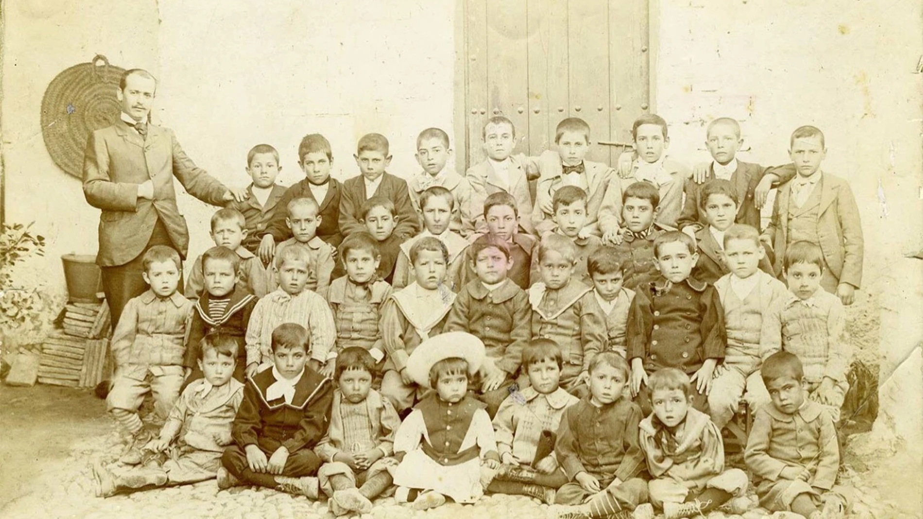 El niño Federico García Lorca, en el centro de la imagen, sentado y vestido de blanco, rodeado de los alumnos de Antonio Rodríguez Espinosa en Fuente Vaqueros