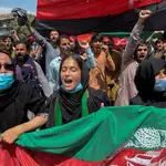 Afganos sostienen banderas nacionales mientras celebran el Día de la Independencia en Kabul, Afganistán