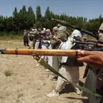 Combatientes talibanes entrenan con sus armas en algún lugar de Afganistán