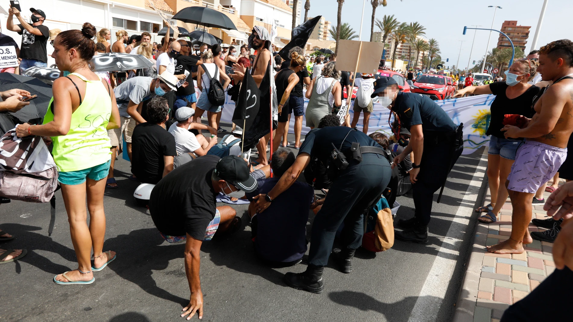 Policías nacionales actúan frente a participantes de una protesta que reivindica la defensa del Mar Menor, al paso de la Vuelta Ciclista a España, a 21 de agosto de 2021, en La Manga