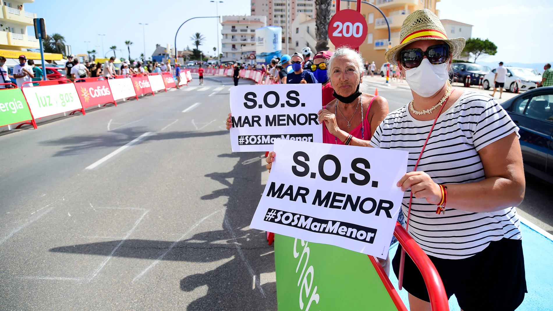 Varias personas participan en una protesta en defensa del Mar Menor al paso de la Vuelta Ciclista a España, a 21 de agosto de 2021, en La Manga, Región de Murcia (España)