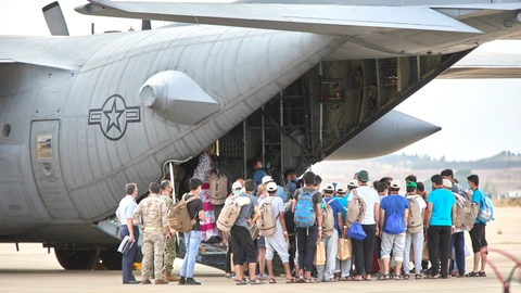 Un grupo de jóvenes y familias afganas, se dirigen a subir a un avión estadounidense para ser trasladados a Alemania, el pasado 24 de agosto