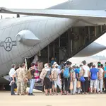 Un grupo de jóvenes y familias afganas, se dirigen a subir a un avión estadounidense para ser trasladados a Alemania, el pasado 24 de agosto