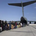 Imagen de un grupo de personas que embarcan en un avión USA para abandonar Afganistán (Master Sgt. DonIald R. Allen/U.S. Air Force via AP)