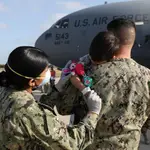 Una militar atiende a un niño afgano en la base aérea de Rota, en Cádiz