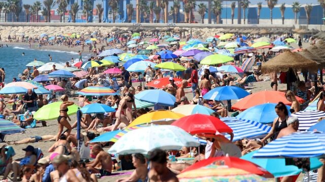 Playa de la Malagueta, en Málaga capital, cubierta por un mar de sombrillas en una multitudinaria jornada de agosto