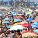 Playa de la Malagueta, en Málaga capital, cubierta por un mar de sombrillas en una multitudinaria jornada de agosto