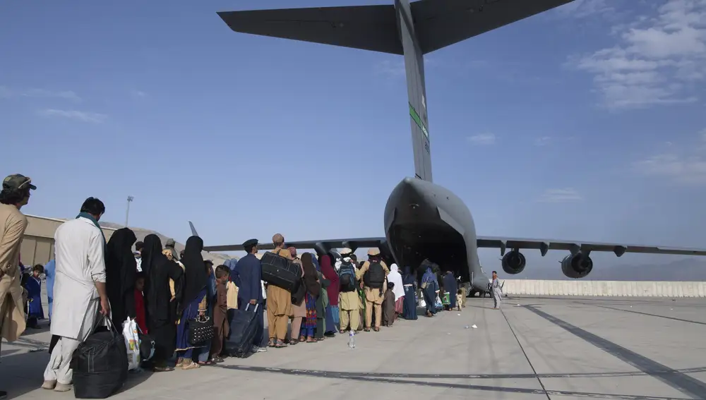 Afganos esperan para subir a un avión de evacuación de las fuerzas norteamericanas en Kabul