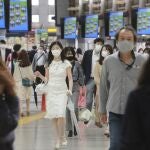 Personas con mascarilla caminan por la estación de tren en Tokio