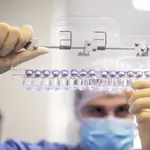 Un técnico inspecciona viales llenos de la vacuna Pfizer-BioNTech COVID-19 en las instalaciones de la compañía en Puurs, Bélgica