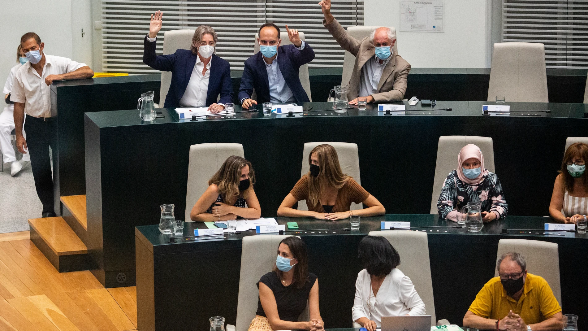 Marta Higueras; José Manuel Calvo, y Luis Cueto, levantan la mano acompañados de concejales de Más Madrid durante la sesión