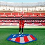 El delantero francés Antoine Griezmann, último fichaje del Atlético de Madrid, posa con su nuevo dorsal sobre le césped del Wanda Metropolitano, este miércoles en Madrid.