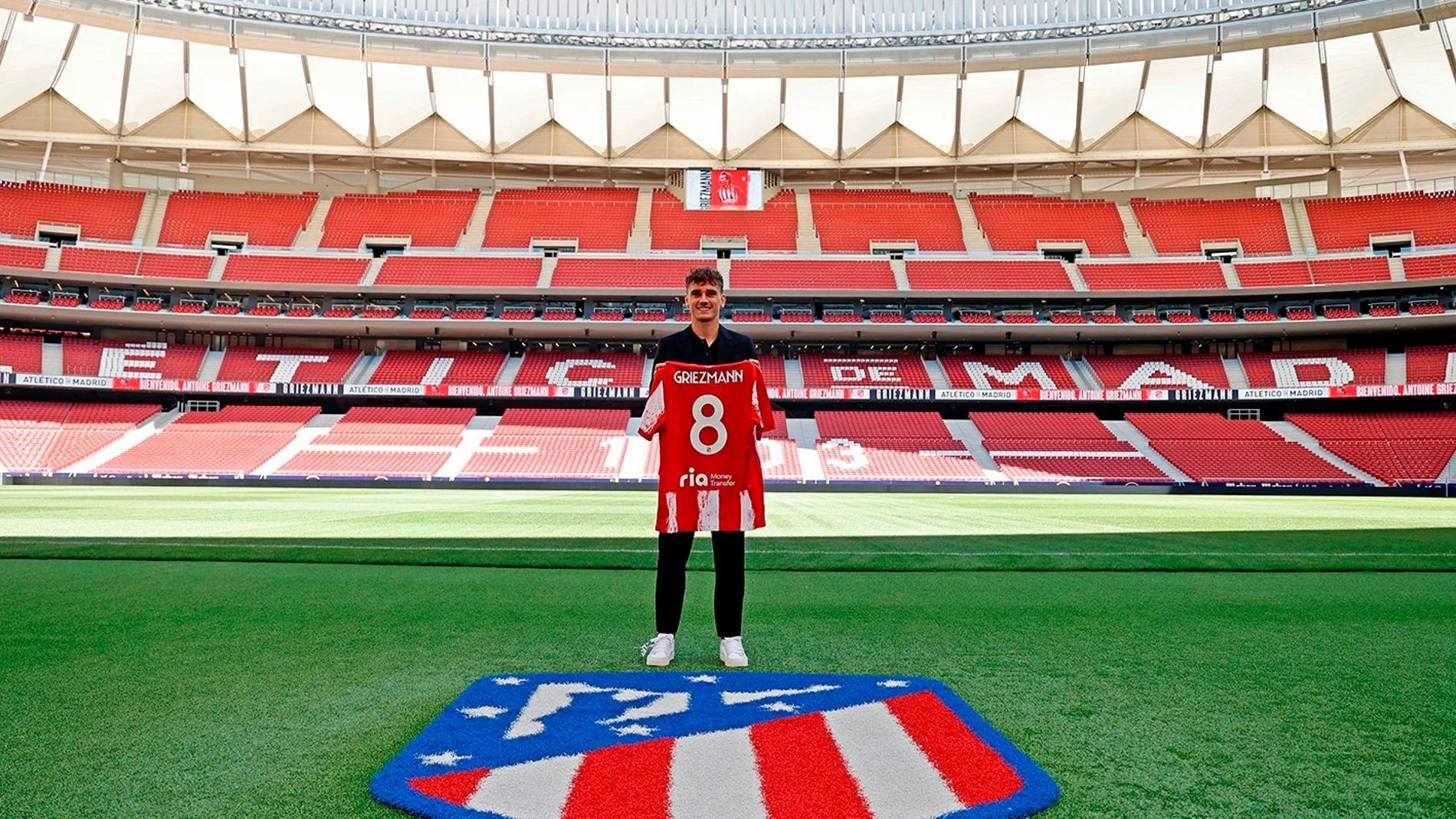 El delantero francés Antoine Griezmann, último fichaje del Atlético de Madrid, posa con su nuevo dorsal sobre le césped del Wanda Metropolitano, este miércoles en Madrid.