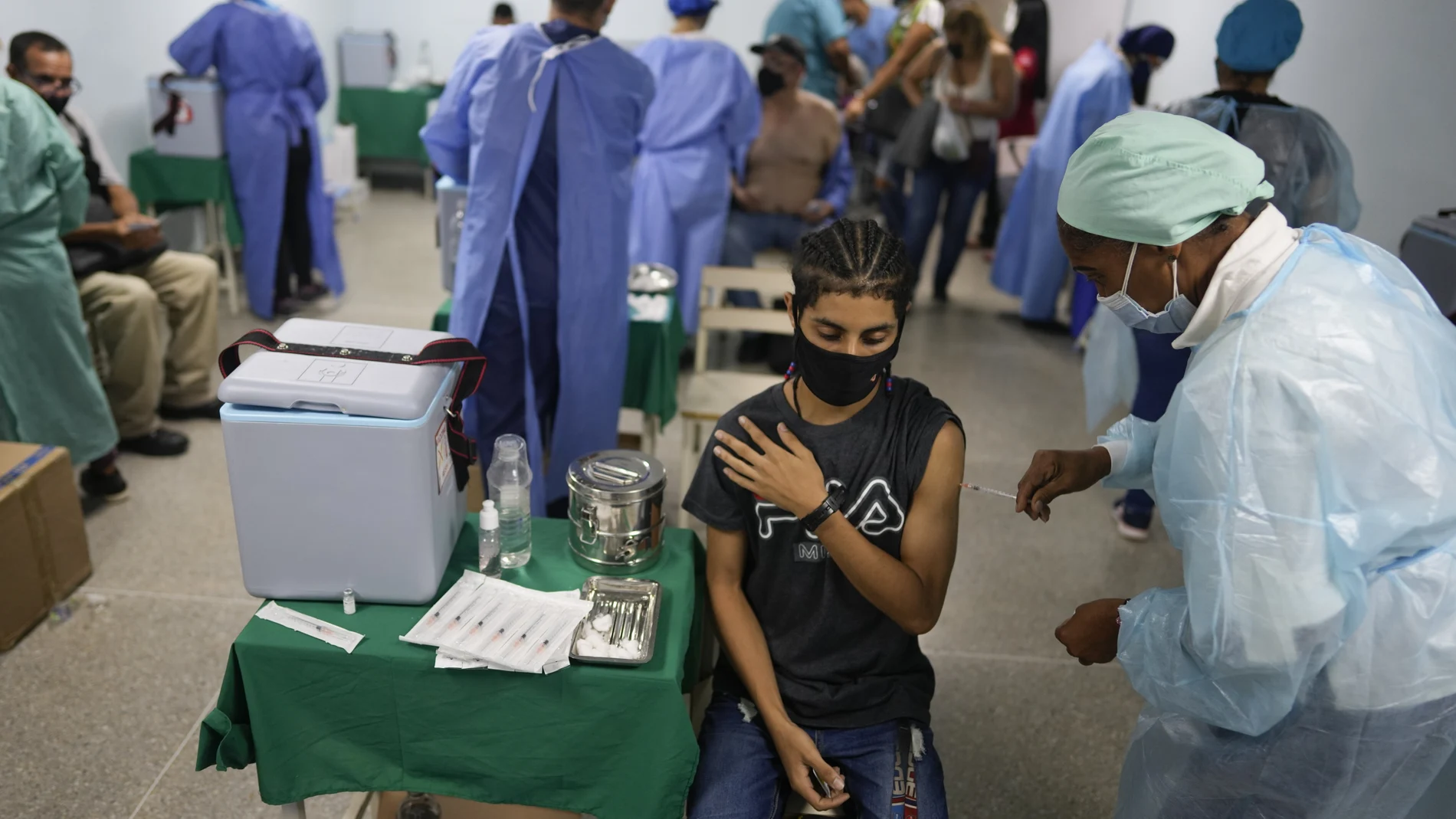 A healthcare worker inoculates a man with a dose of the Sinopharm COVID-19 vaccine, at a government health center in Caracas, Venezuela, Wednesday, Sept. 8, 2021. (AP Photo/Ariana Cubillos)