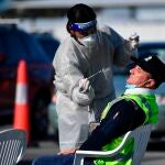 Un sanitario hace un test Covid-19 a un trabajador del Aeropuerto Internacional de Sídney