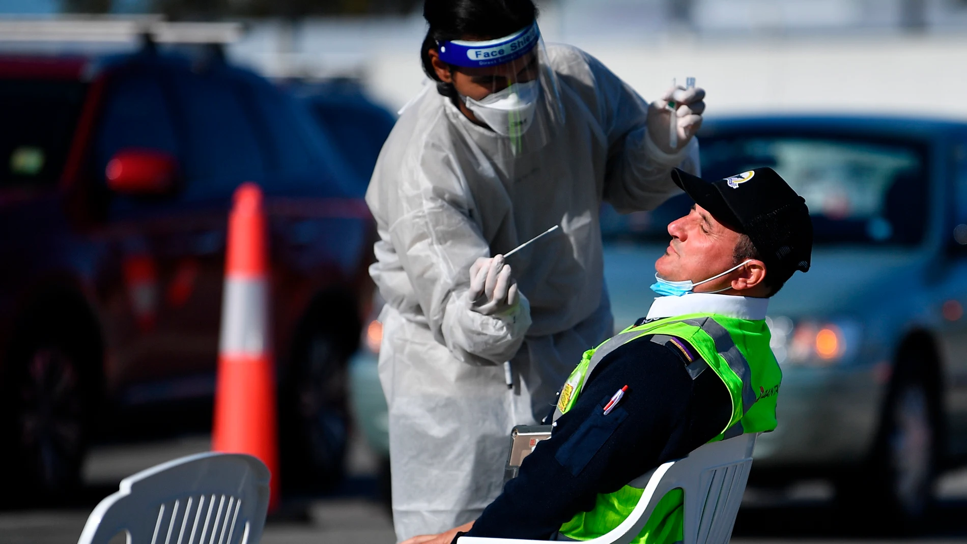 Un sanitario hace un test Covid-19 a un trabajador del Aeropuerto Internacional de Sídney